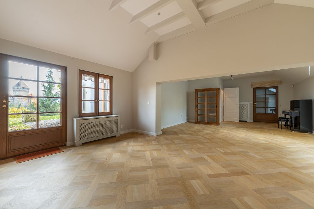 Heller Wohnraum mit Holzdielen und großen Fenstern