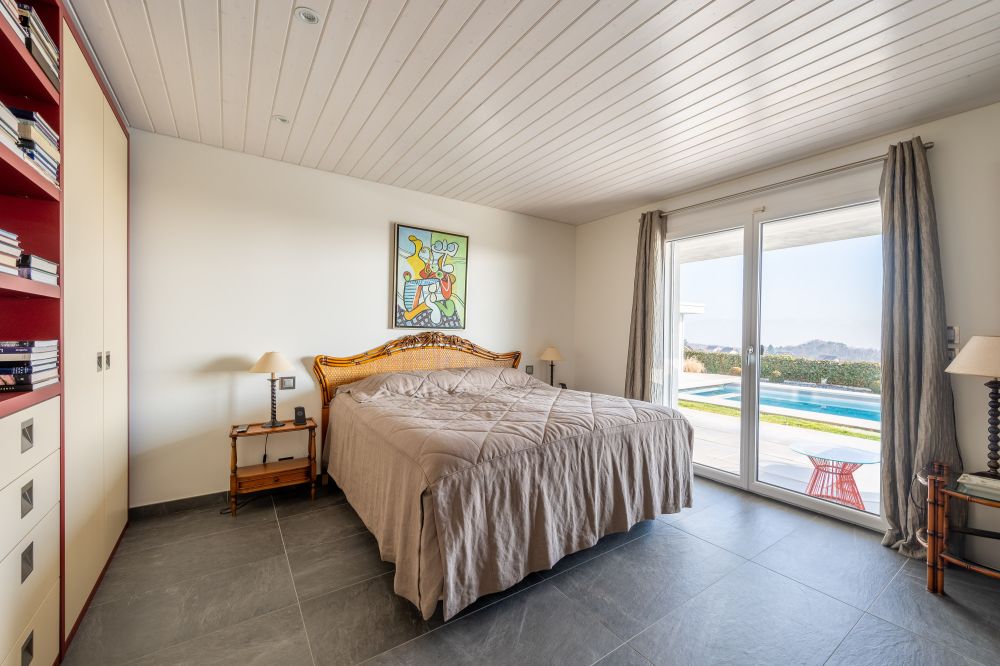 Schlafzimmer mit Terrassentür und Poolblick