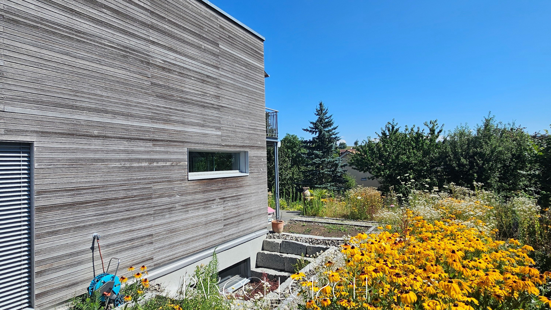 Moderner Holzbau mit Gartenansicht