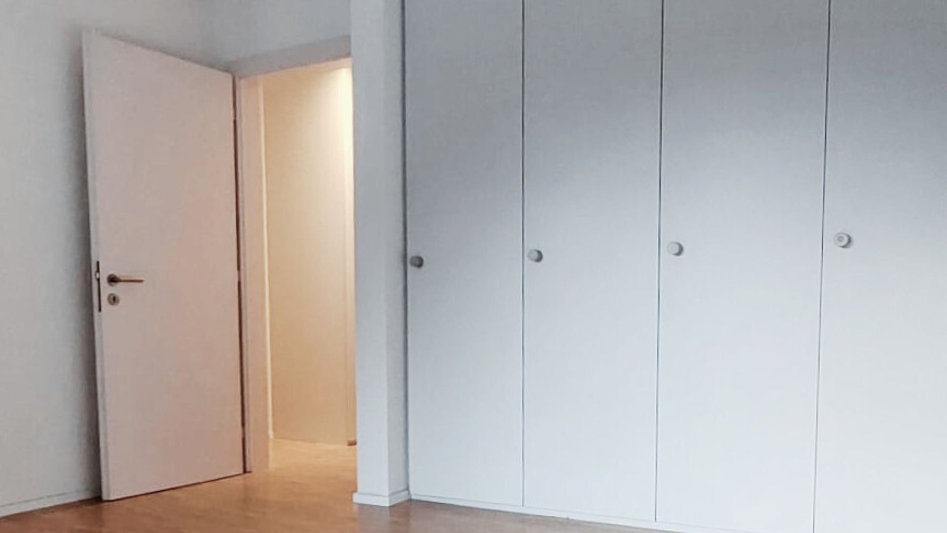 Helles Schlafzimmer mit Einbauschrank und offener Tür