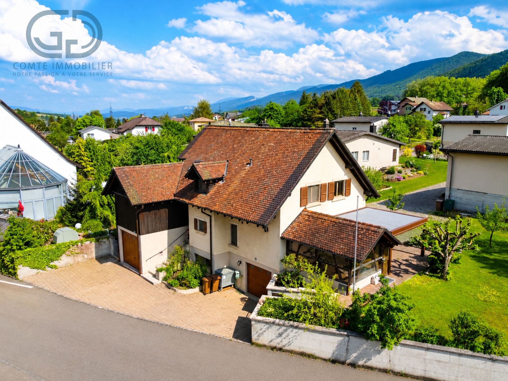 Luftaufnahme eines Einfamilienhauses mit Bergblick