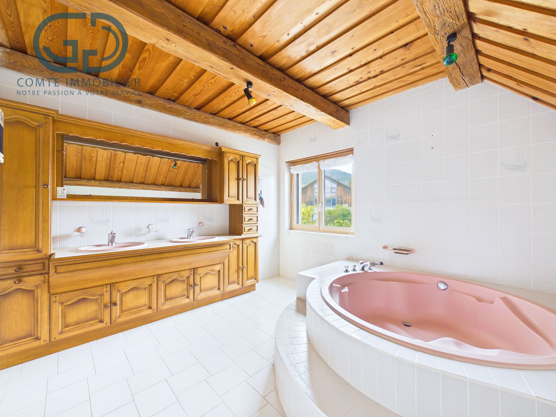 Großes Badezimmer mit Holzdecke und Wanne