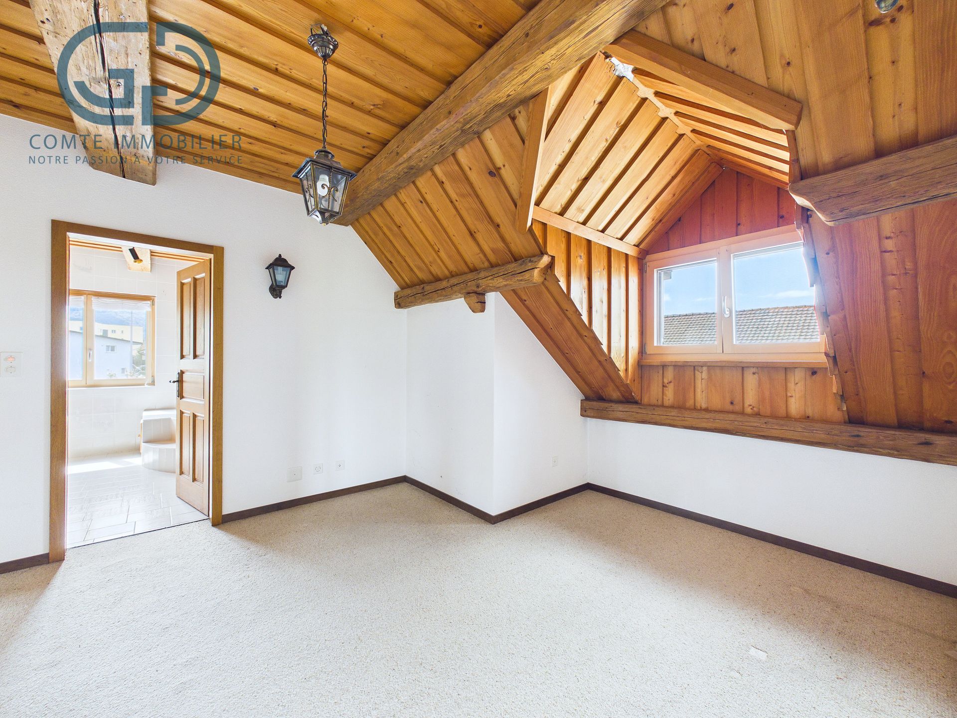 Dachzimmer mit sichtbaren Holzbalken