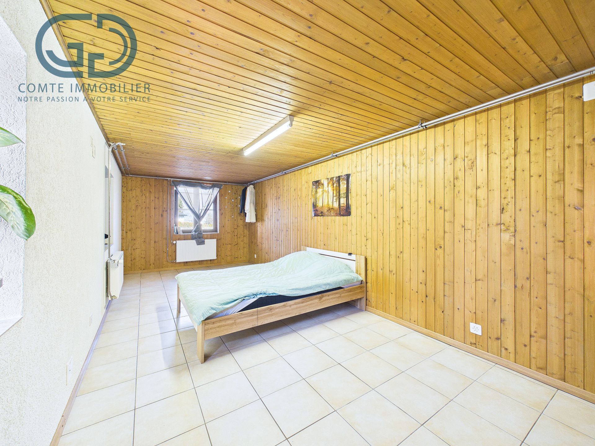 Helles Schlafzimmer mit Holzverkleidung und Fliesenboden