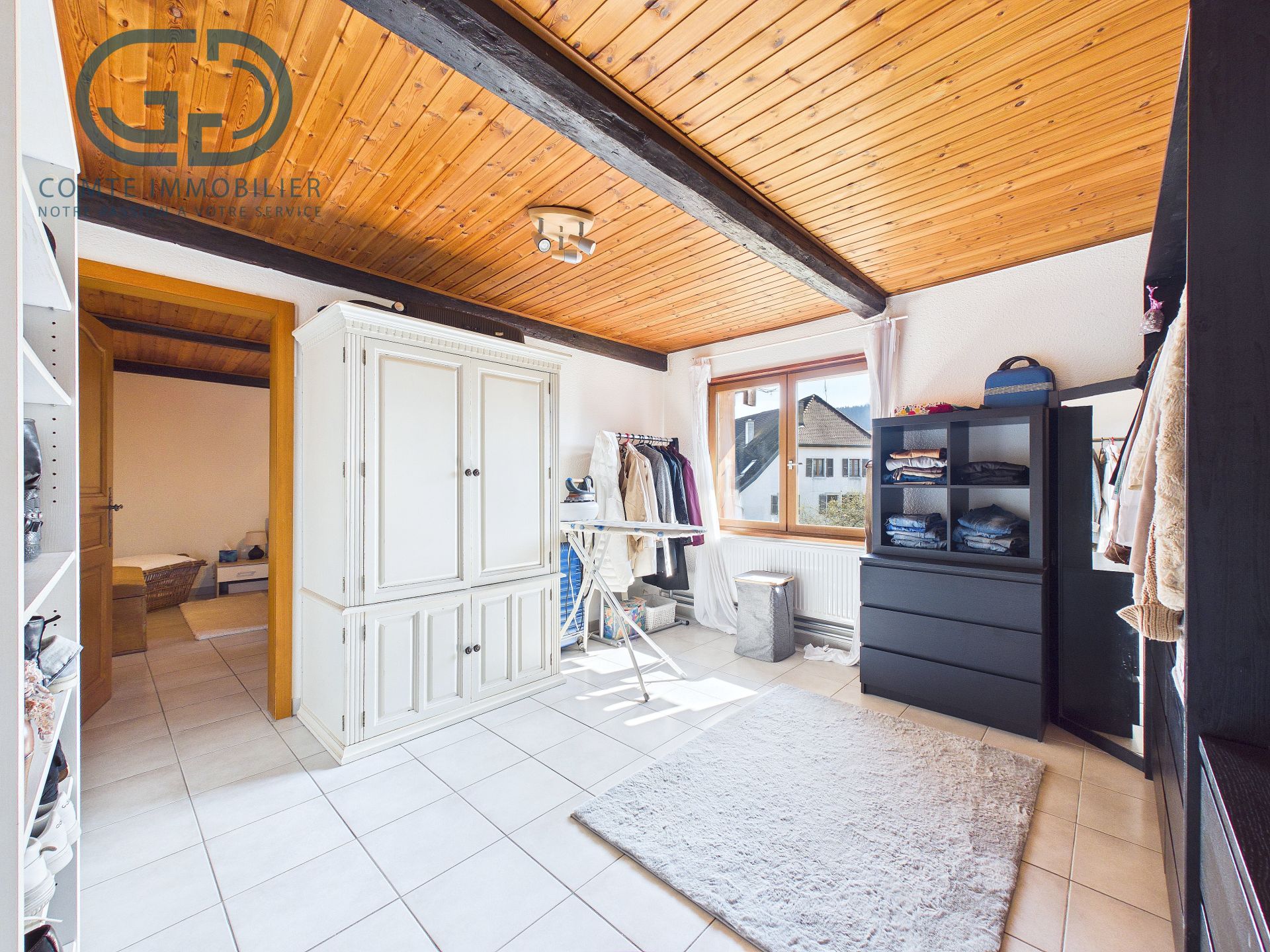 Heller Ankleide- bzw. Schlafzimmerbereich mit sichtbarer Holzdecke
