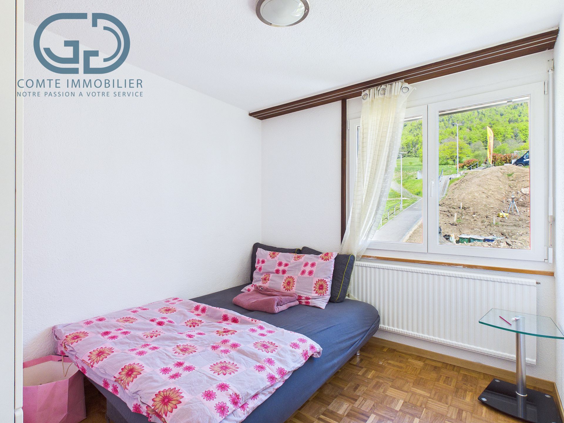 Helles Schlafzimmer mit Einzelbett und Fensterblick