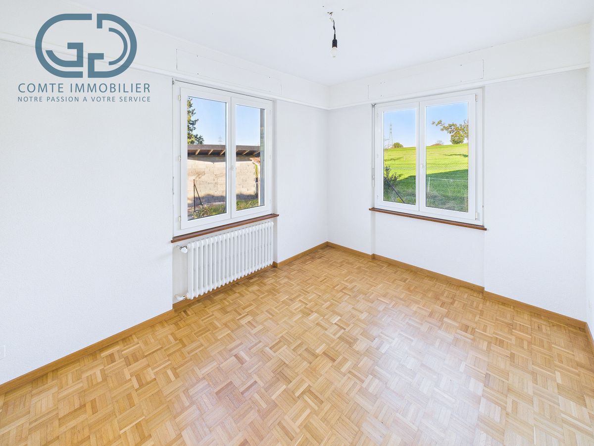 Heller leerer Raum mit zwei Fenstern und Parkettboden