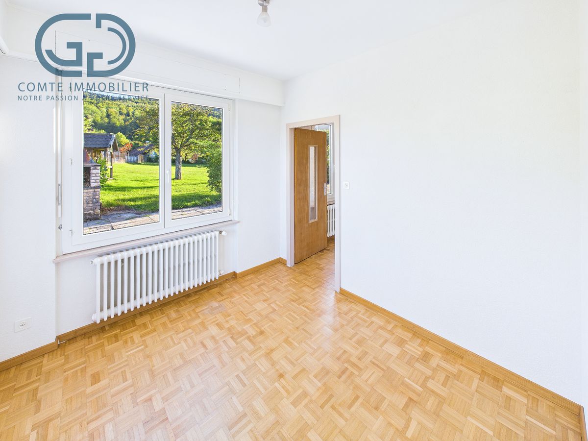 Leerer heller Raum mit Parkett und Fenster