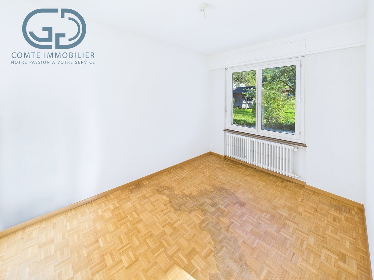 Helles leeres Zimmer mit Parkettboden und Fenster