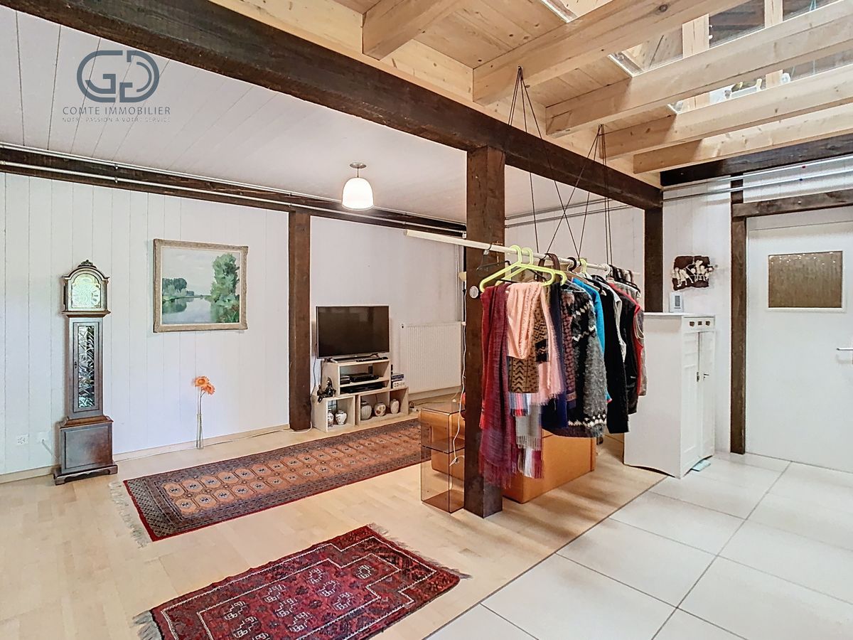 Lichtes Loft-Wohnzimmer mit sichtbarer Galerie und offener Kleiderstange