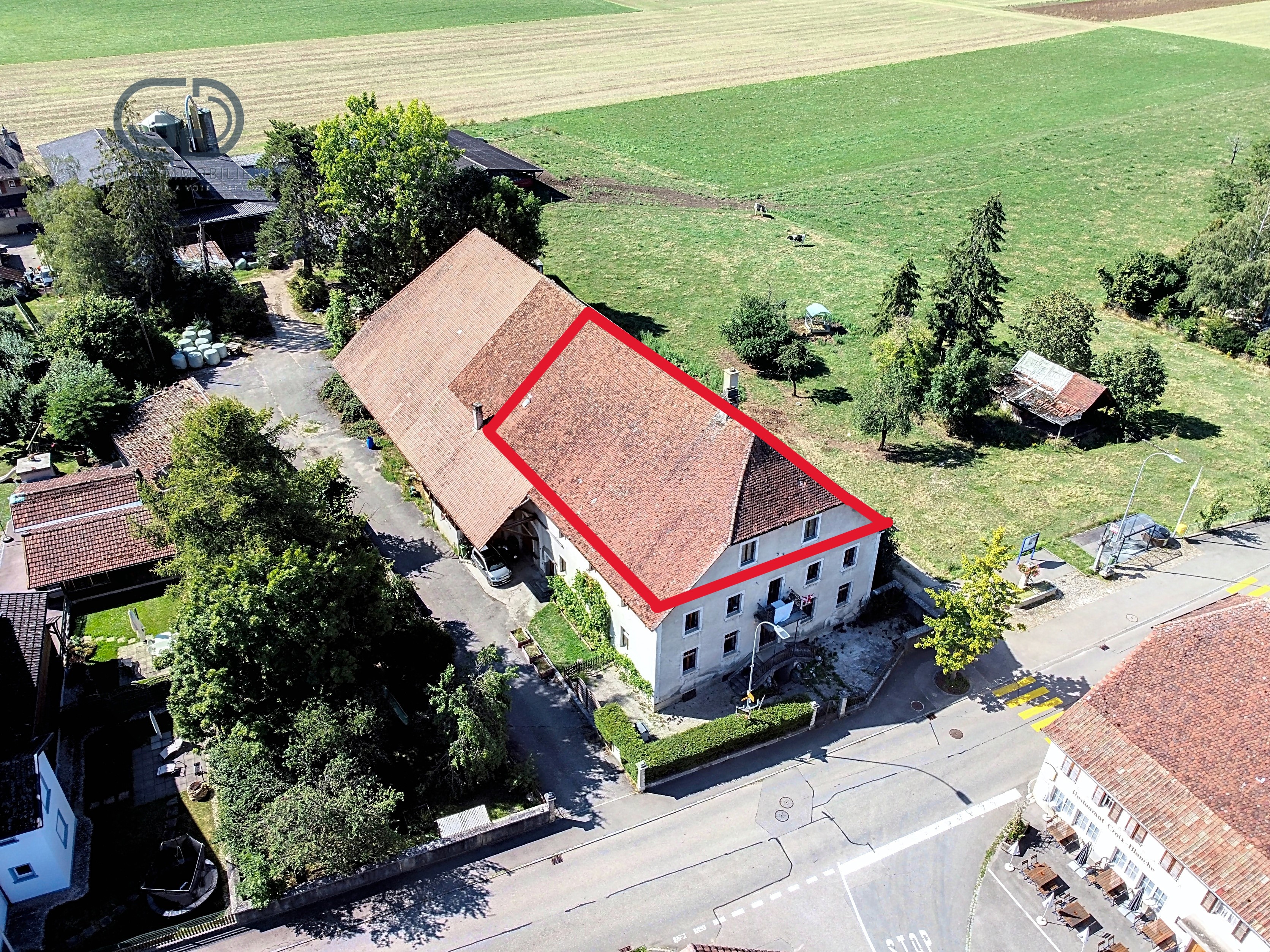 Luftaufnahme eines großen Wohngebäudes mit rotem Ziegeldach