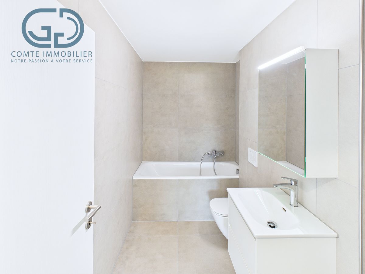 Helles, modernes Badezimmer mit Badewanne und Waschtisch