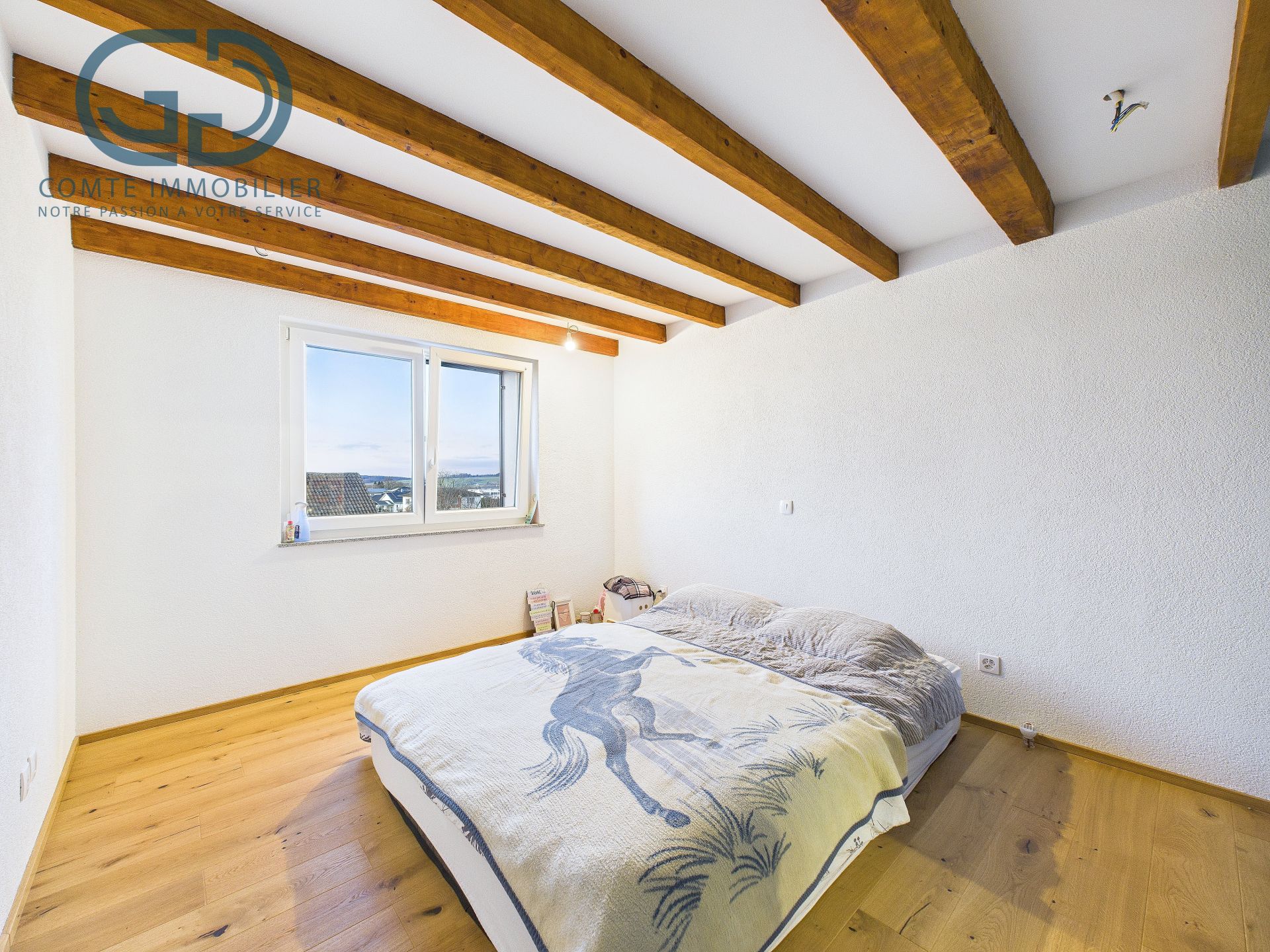 Schlafzimmer mit sichtbaren Holzbalken und Dachschräge