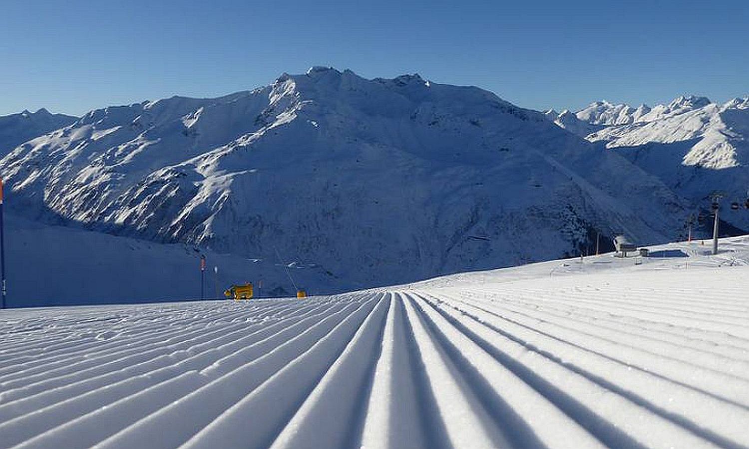 Schneebedeckte Skipiste mit Bergpanorama