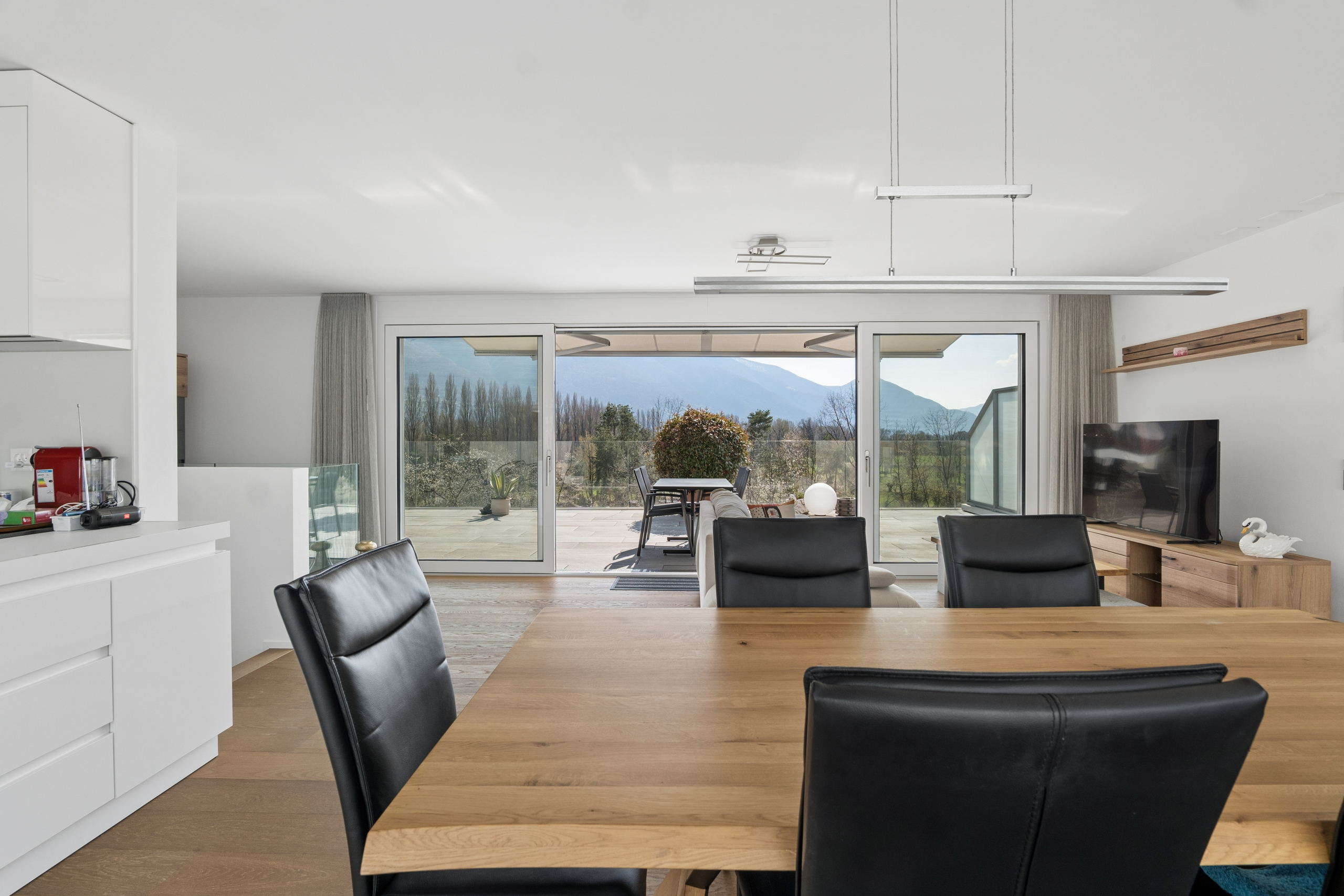 Offener Wohn- und Essbereich mit Terrasse und Bergblick