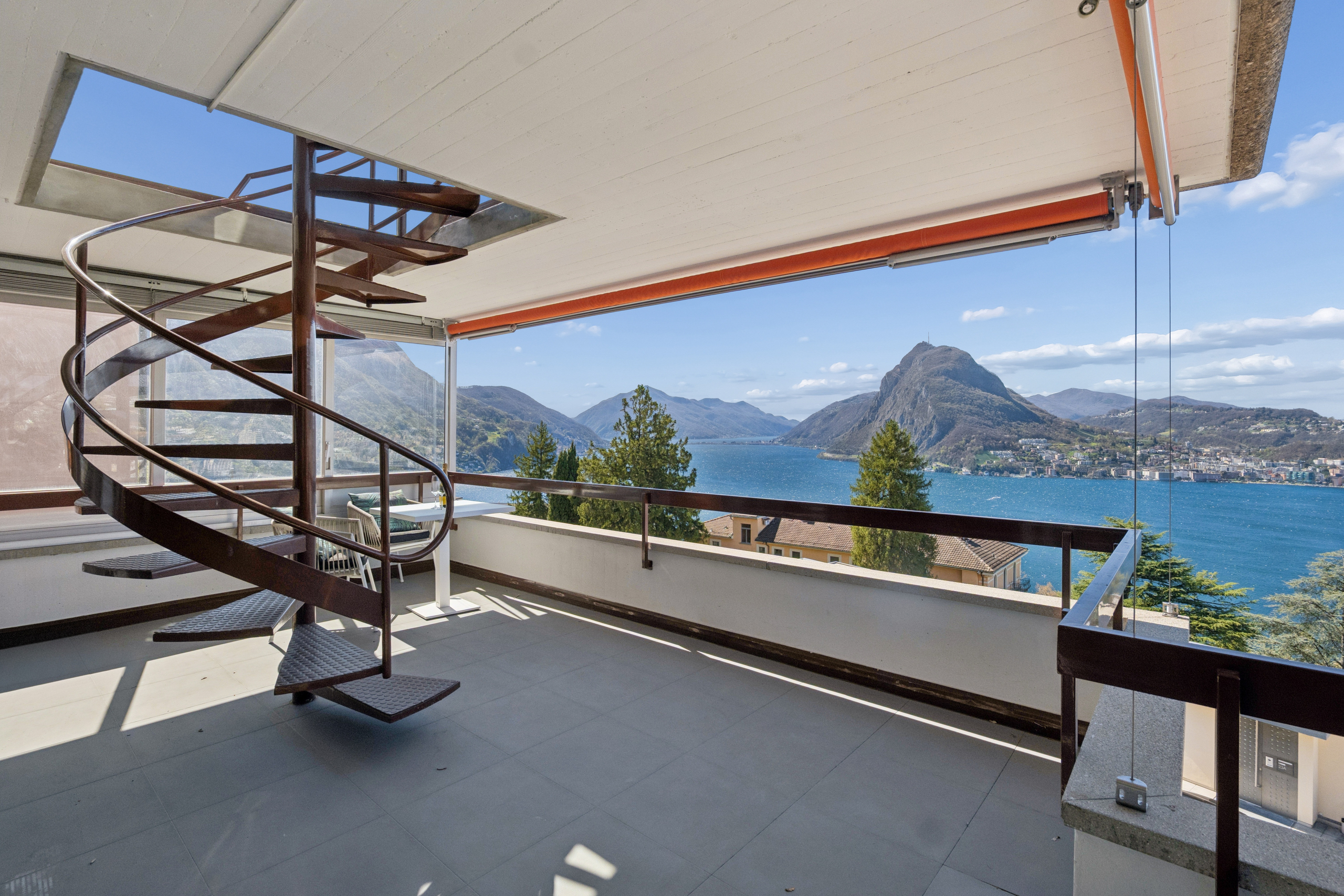 Balkon mit Spiraltreppe und Bergsee-Panoramablick