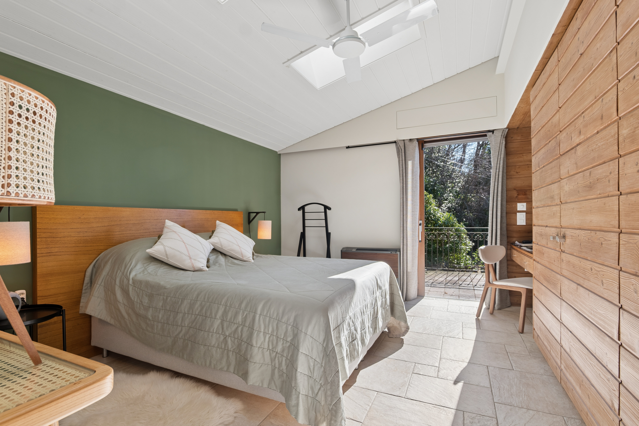 Helles Schlafzimmer mit Holzdetails und Balkonzugang