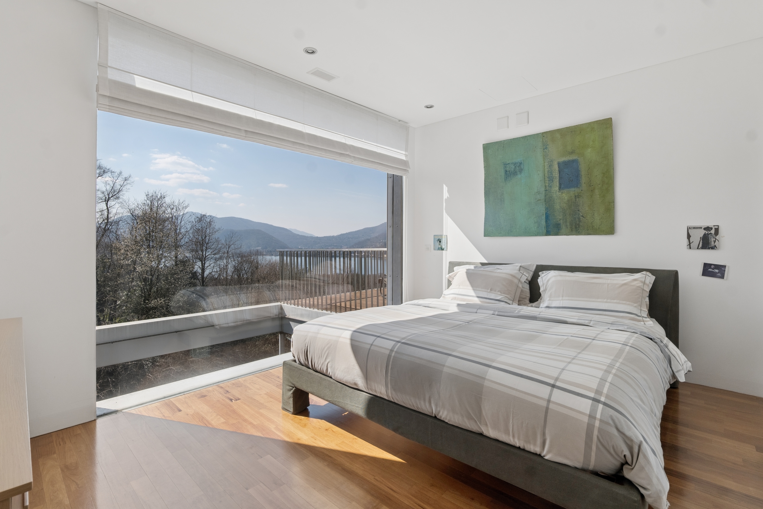 Helles Schlafzimmer mit Panoramafenster und Seeblick