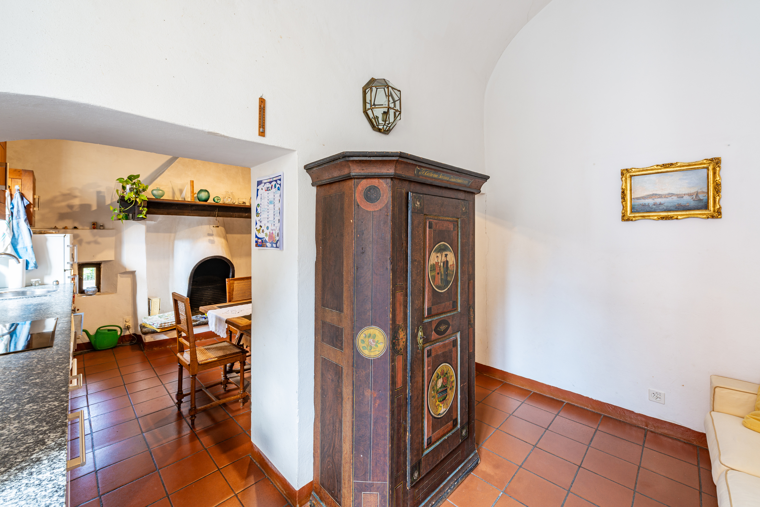 Innenraum mit Terrakottaboden und antikem Schrank
