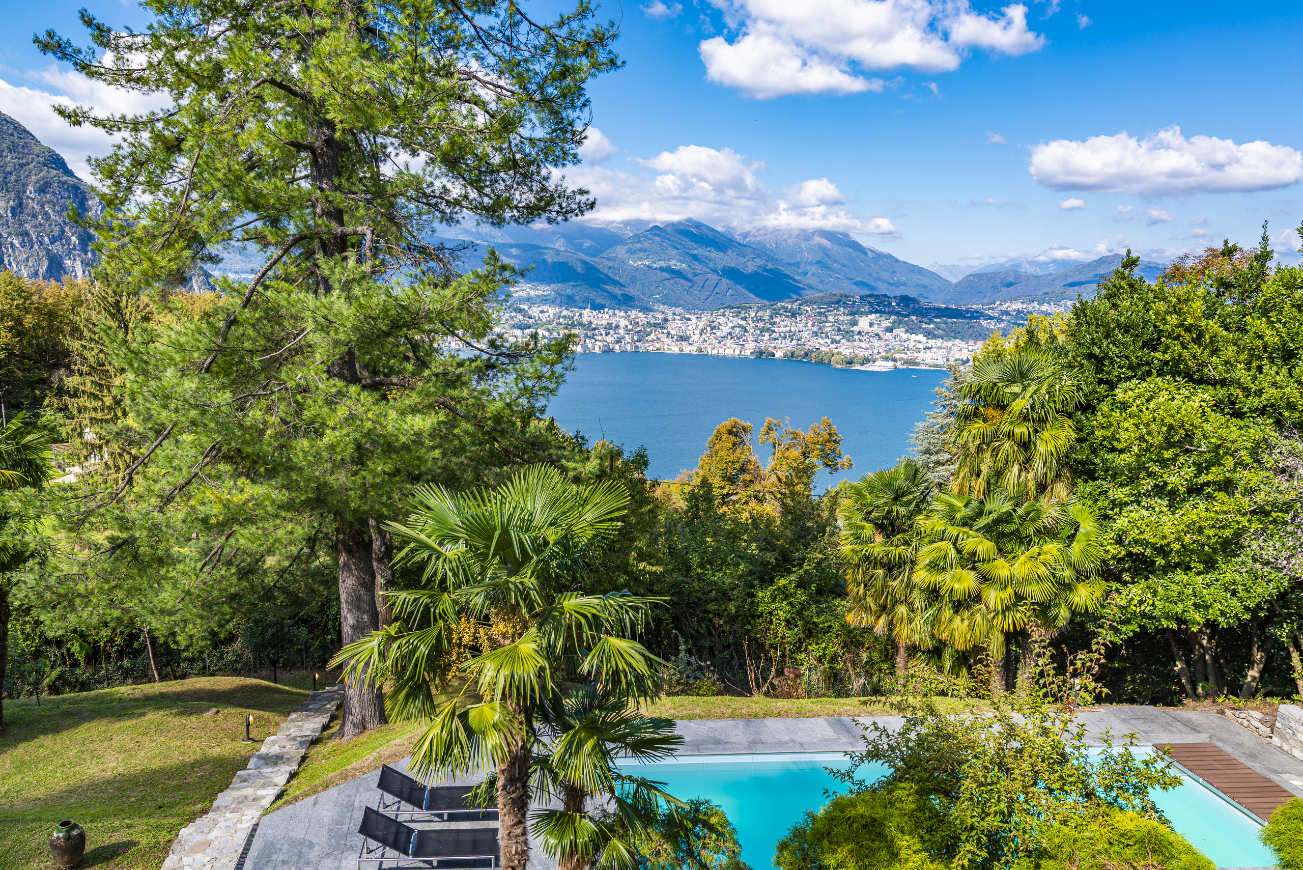Luxuriöser Außenblick mit See, Bergen und Pool