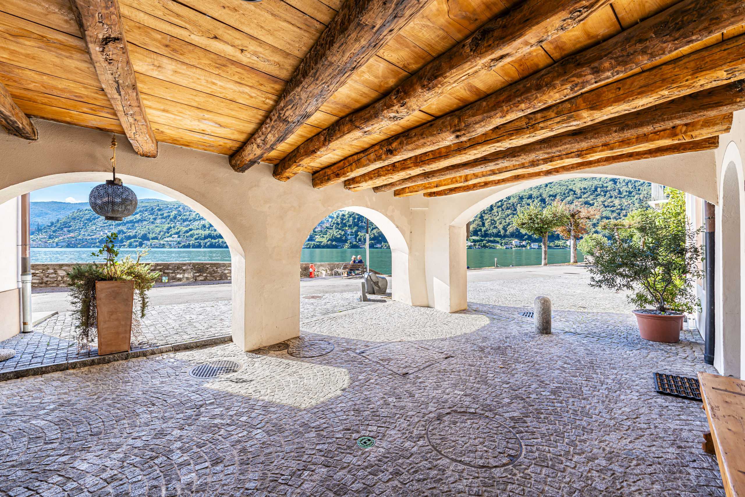 Überdachte Arkade am Wasser mit Bergblick