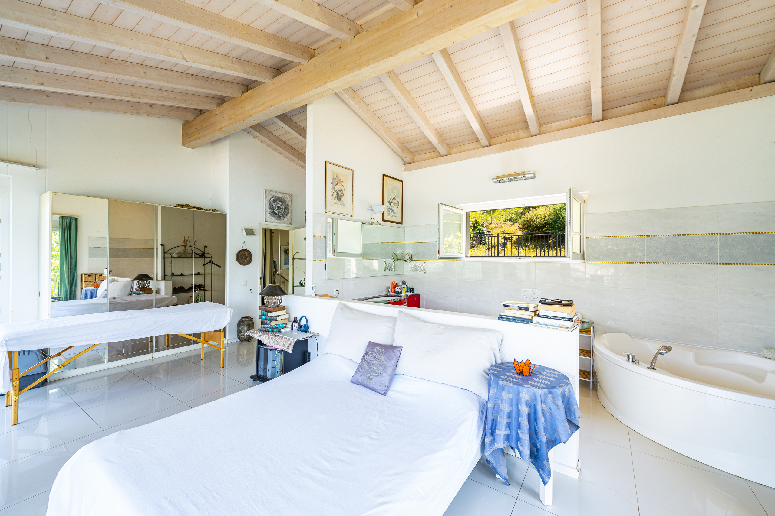 Helles Schlafzimmer mit Badewanne und offenem Raumgefühl