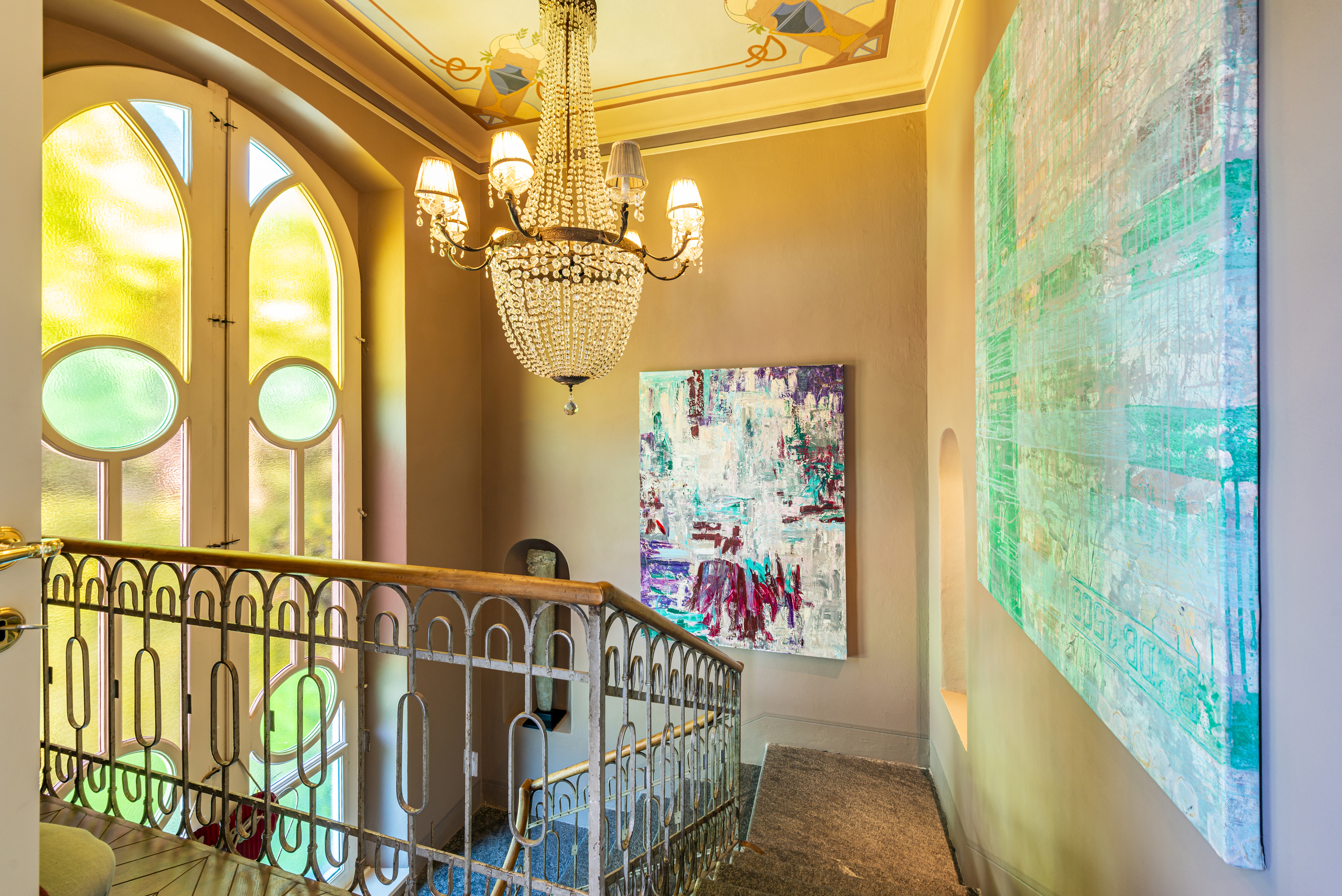 Elegante Galerie mit Kristalllüstern und bunten Glasfenstern