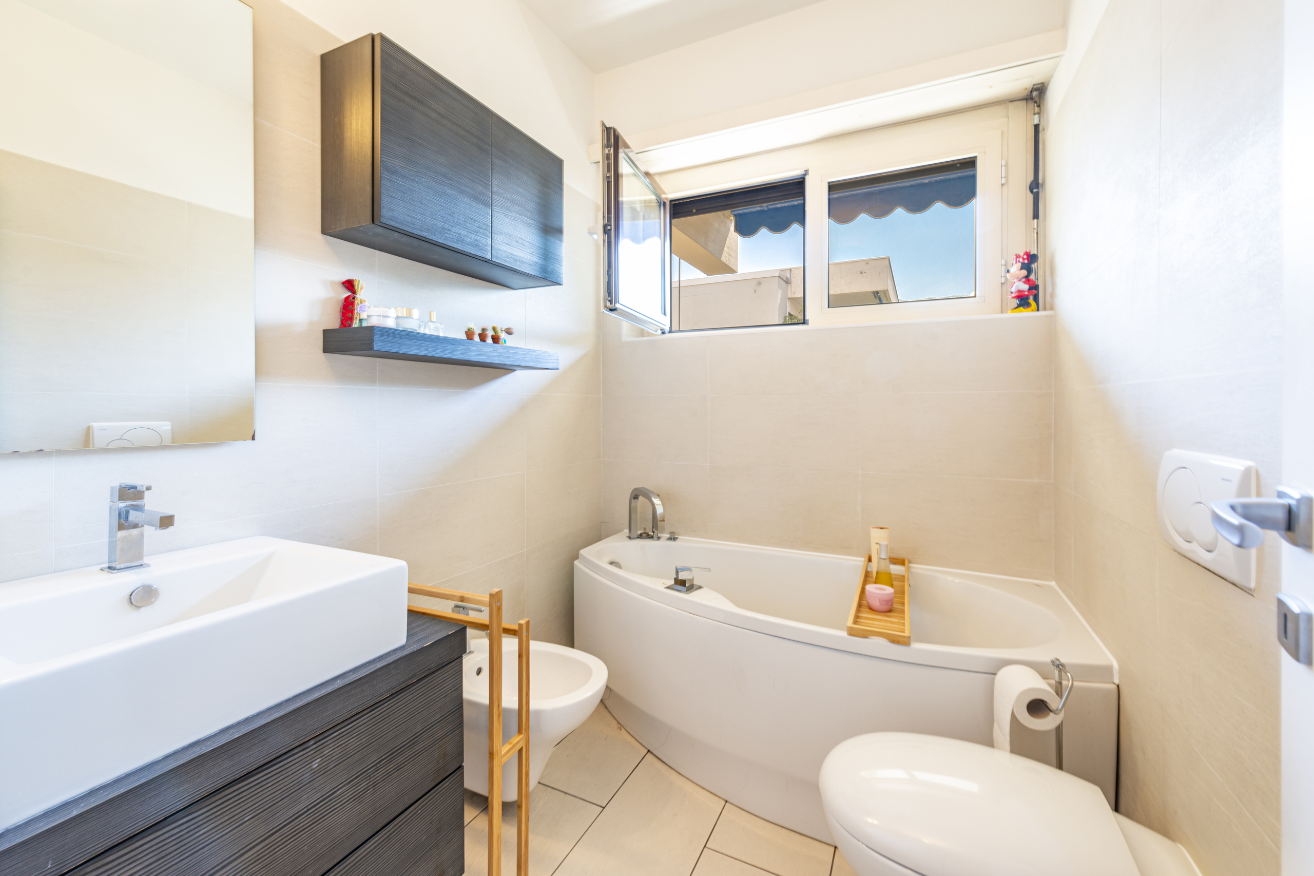 Helles Badezimmer mit Badewanne und Fenster