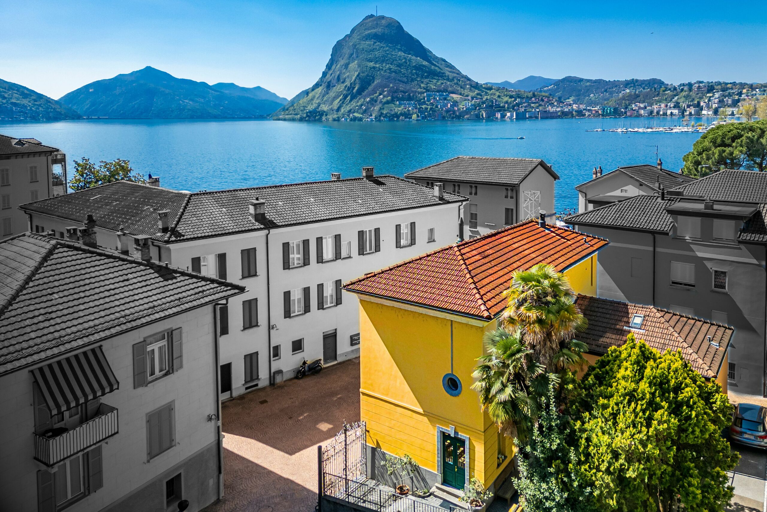 Seeblick mit bergiger Uferlandschaft und Wohnhäusern