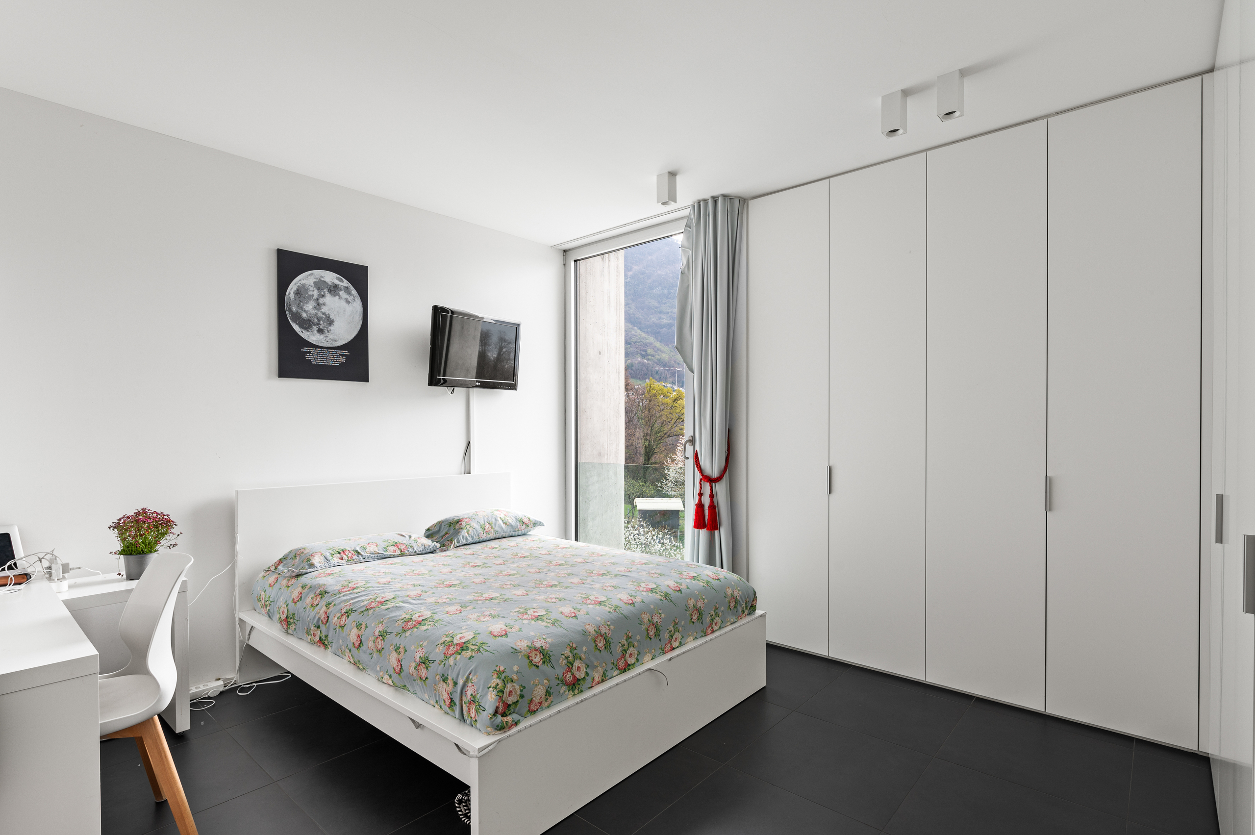 Modernes Schlafzimmer mit Einbauschrank und Blick ins Grüne
