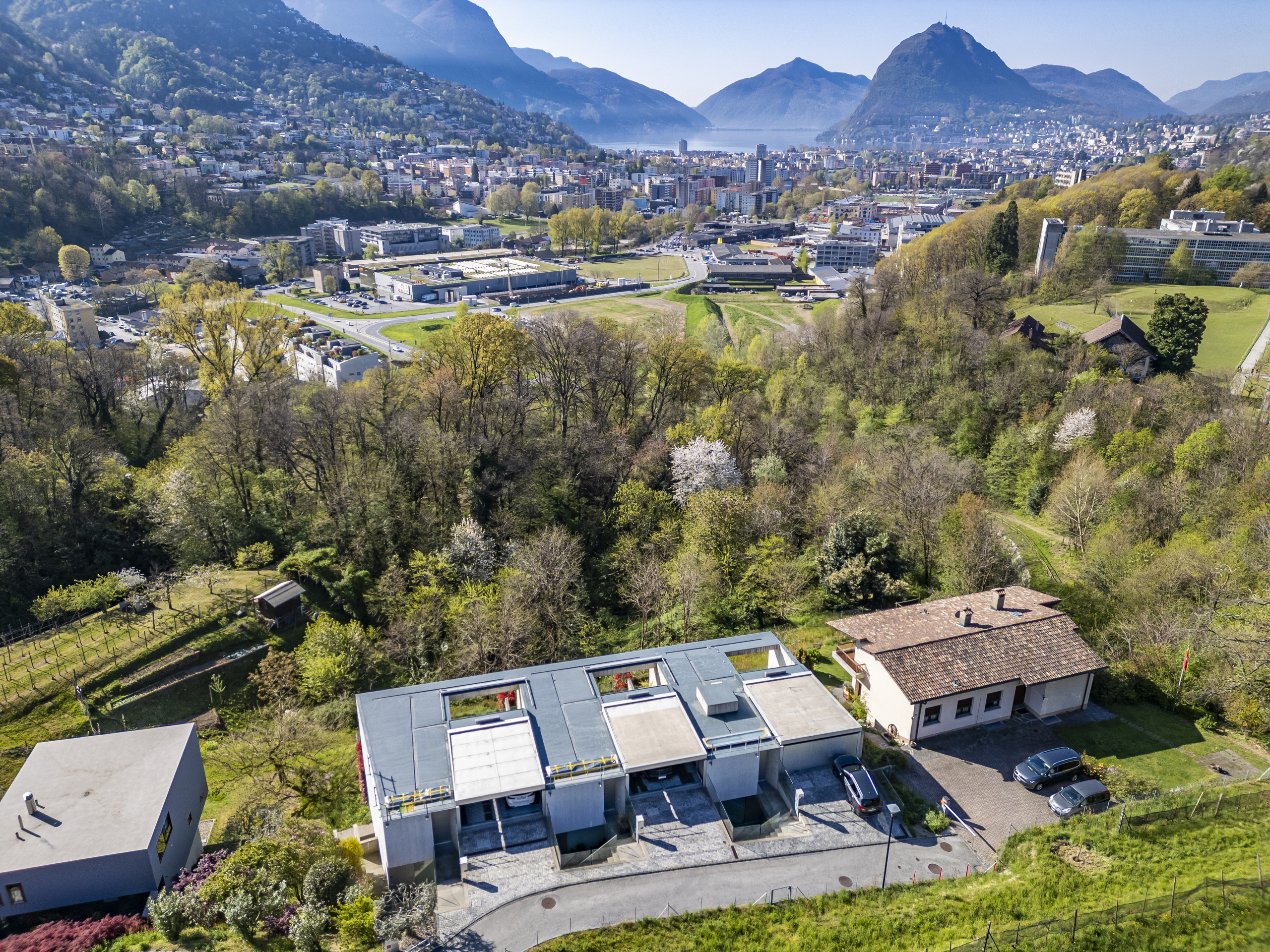 Luftaufnahme einer Stadt am See mit Bergpanorama