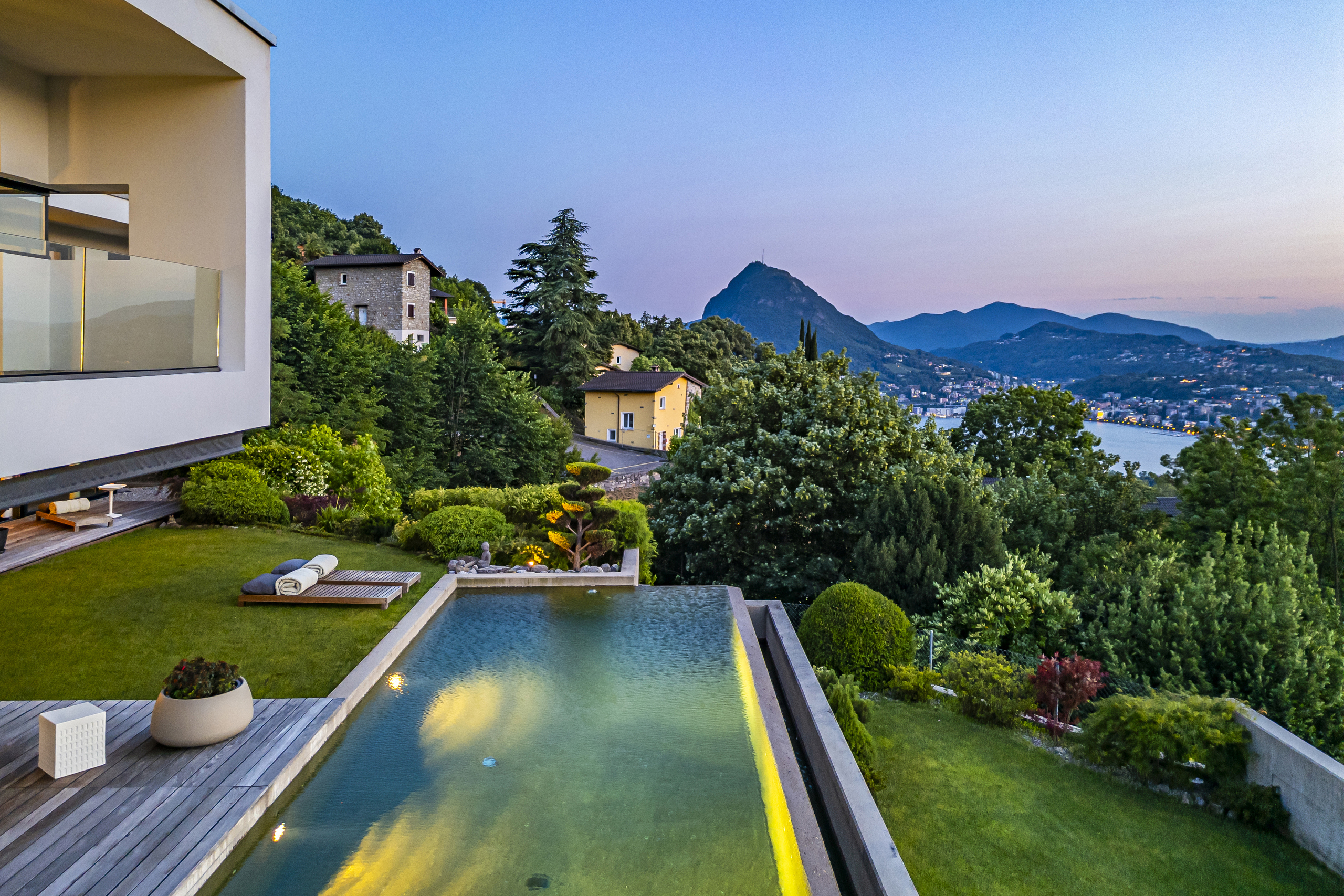 Luxuriöse Außenanlage mit Pool und Bergblick bei Dämmerung