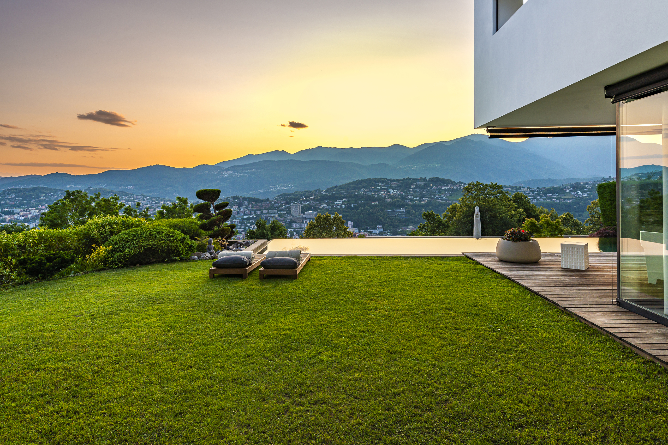 Luxuriöser Garten mit Panorama und Terrasse bei Sonnenuntergang
