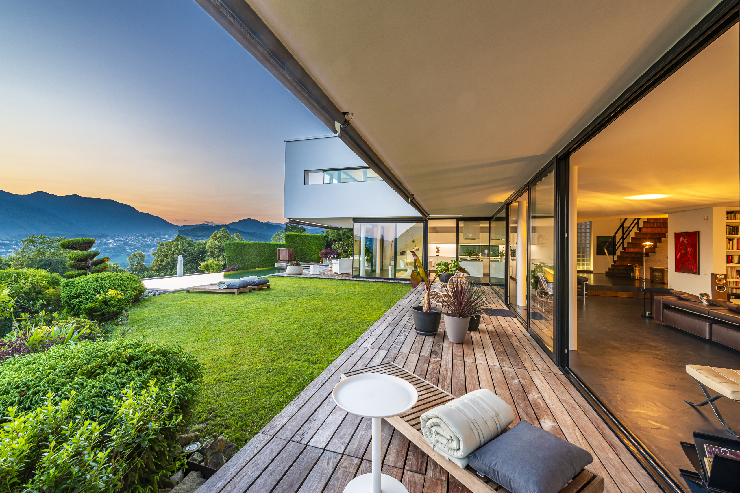 Luxuriöse Terrasse mit Garten und Panoramablick bei Sonnenuntergang