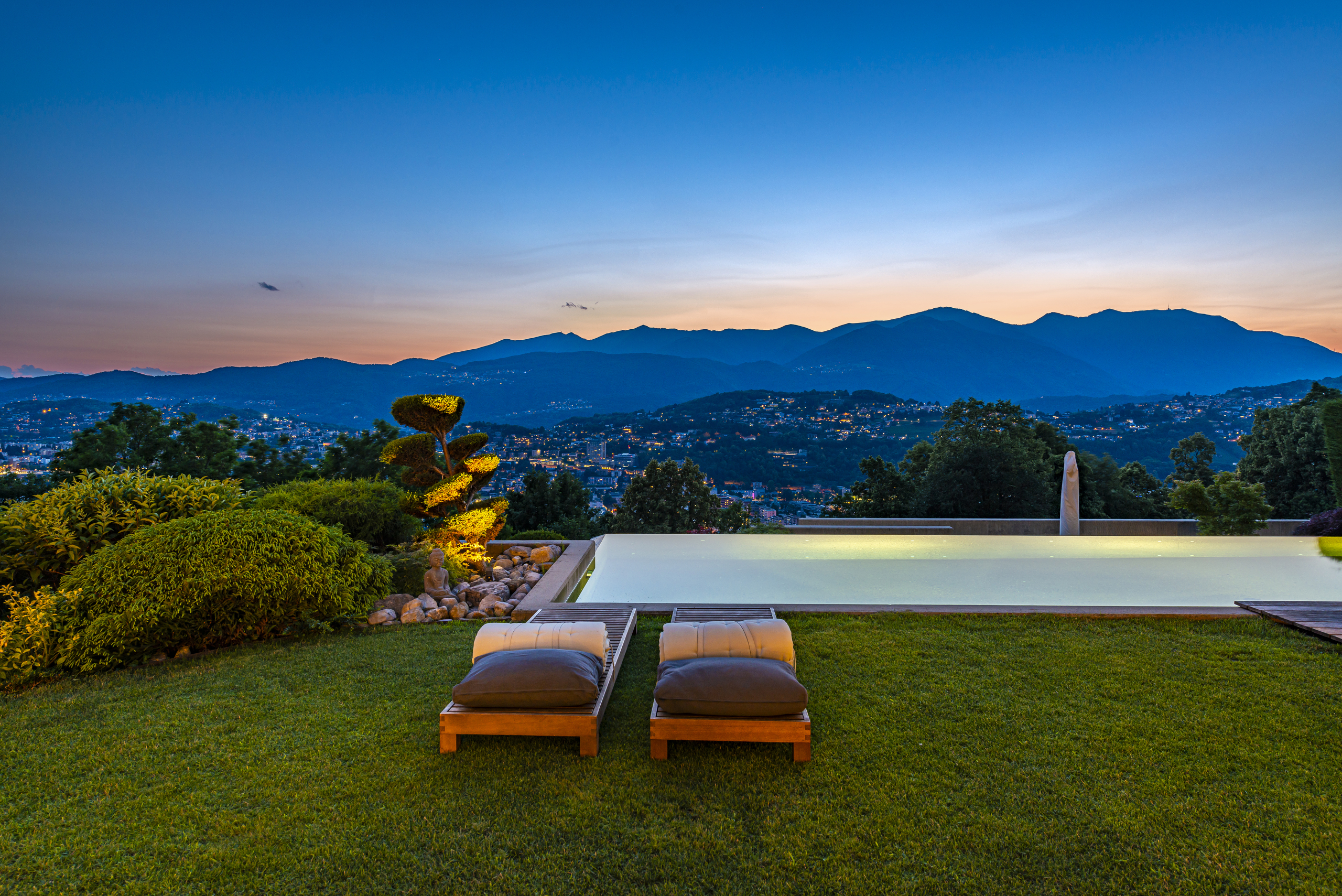 Luxuriöser Außenbereich mit Infinity-Pool und Panoramablick bei Sonnenuntergang