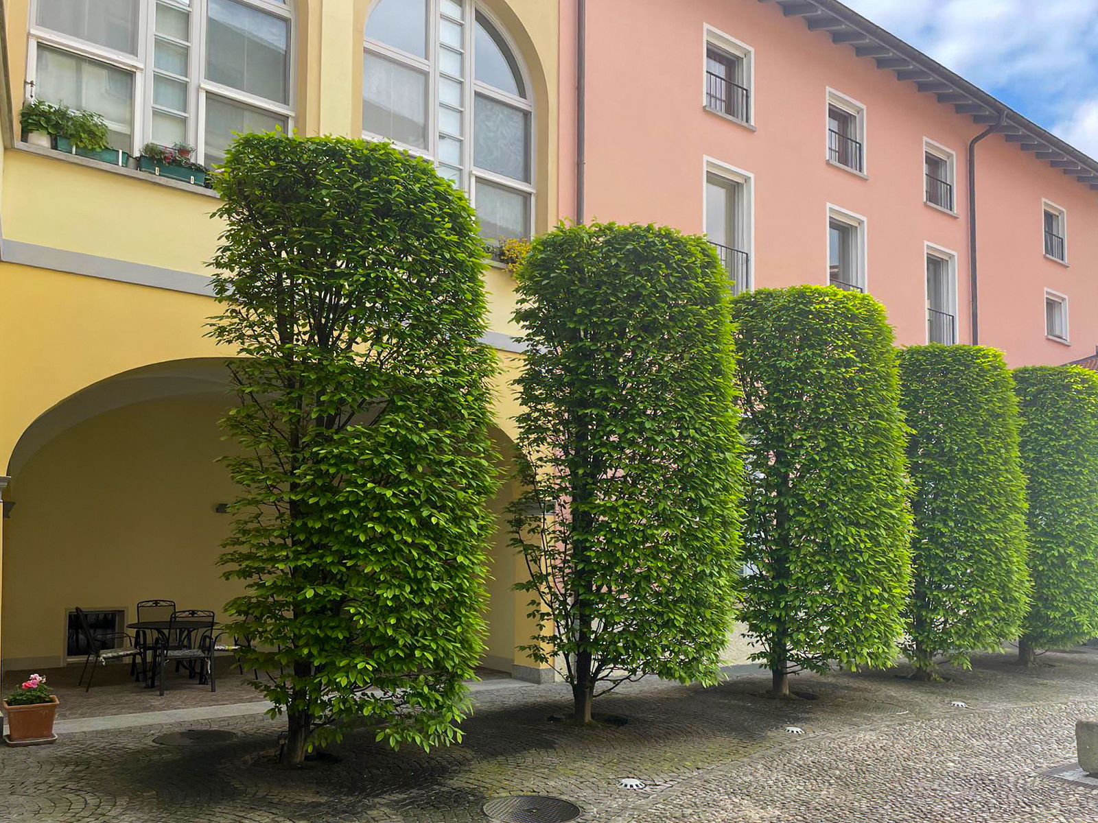 Innenhof mit begrünten Fassaden und Arkaden