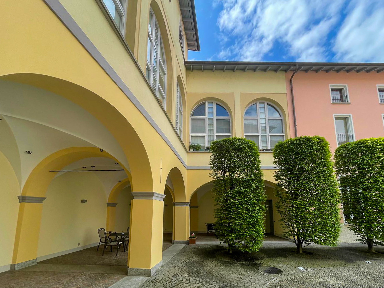Arkadenhof eines Pastellgebäudes