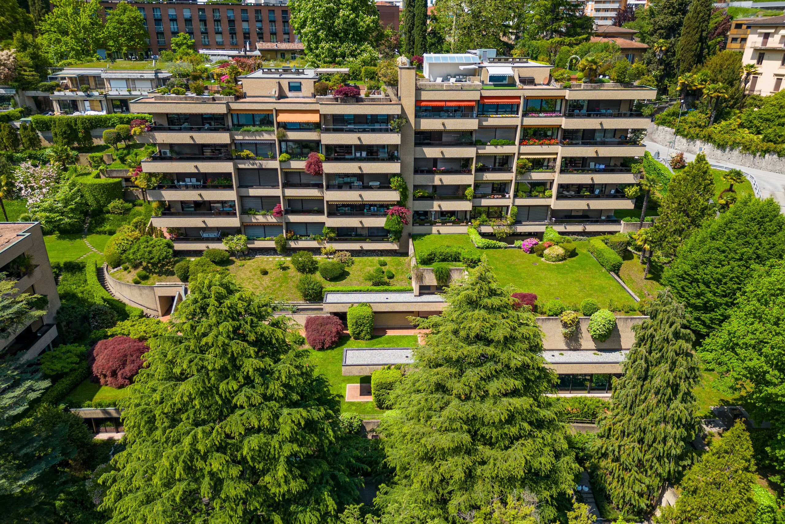 Luftaufnahme einer gepflegten Wohnanlage mit Terrassen und Gärten