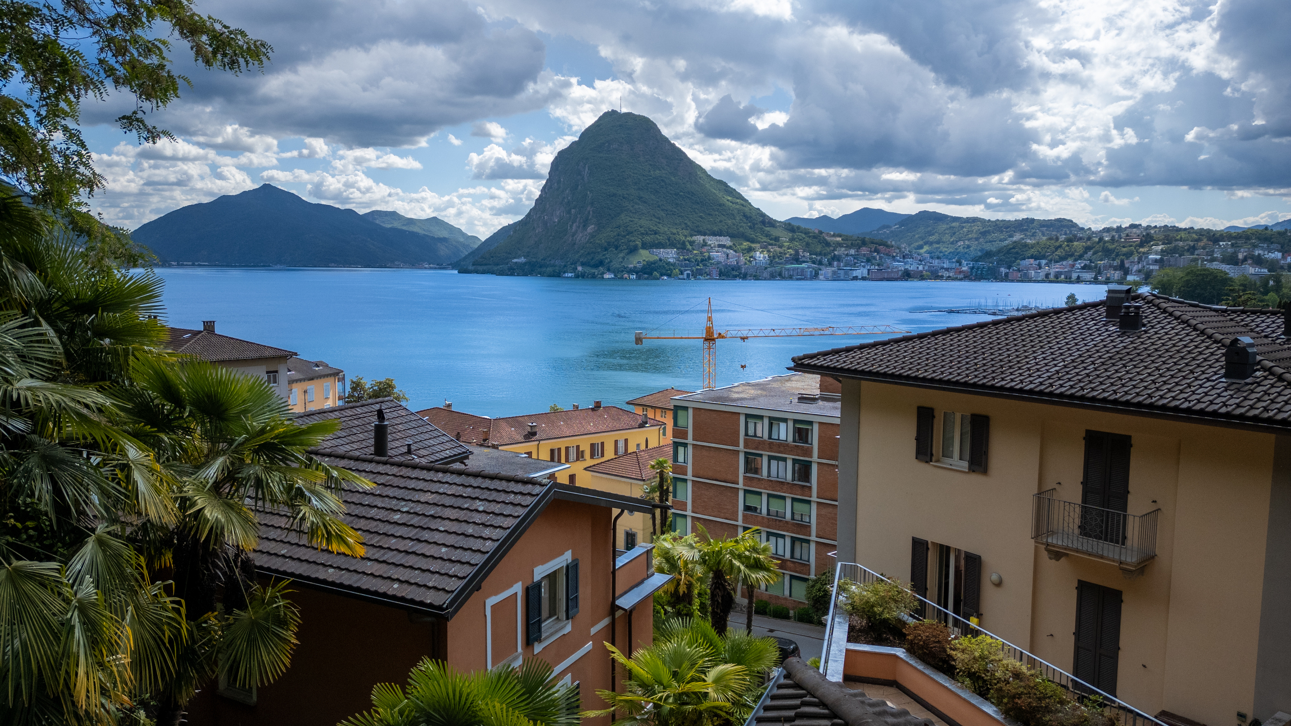 Seeblick mit Bergen und Wohnhäusern