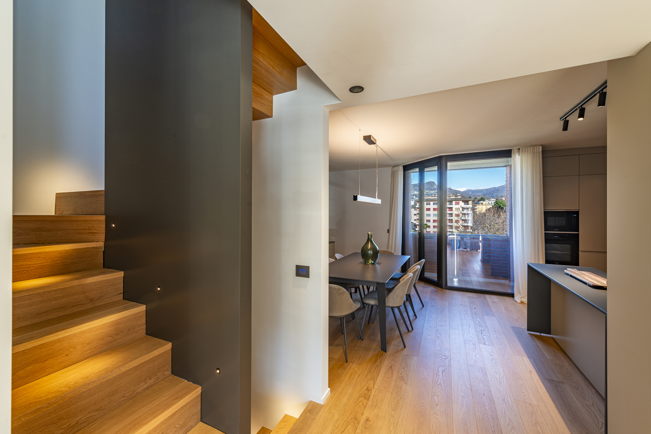 Moderne Wohn-Esszone mit Treppe und Balkonblick