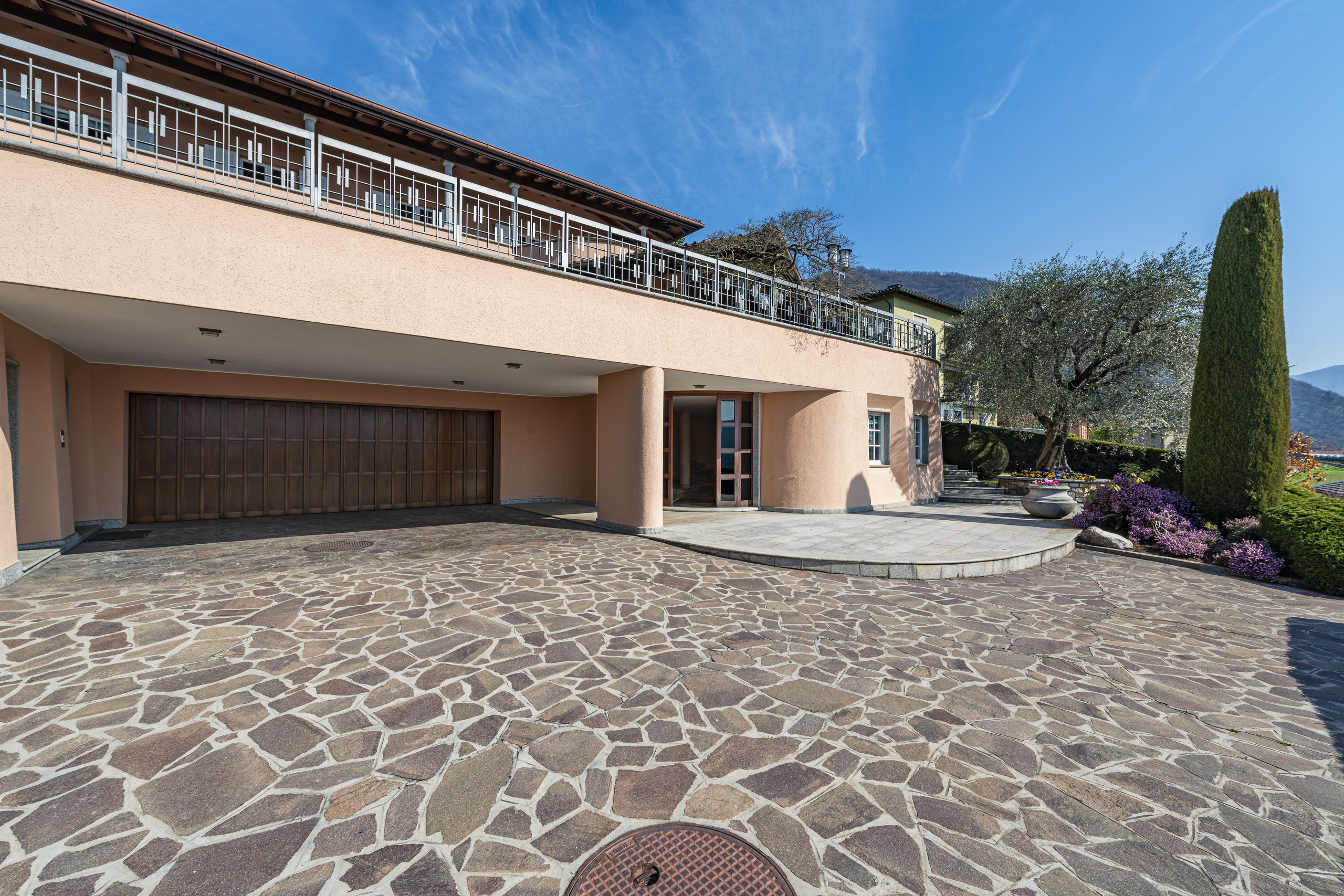 Außenansicht einer mediterranen Villa mit Garage und Terrasse