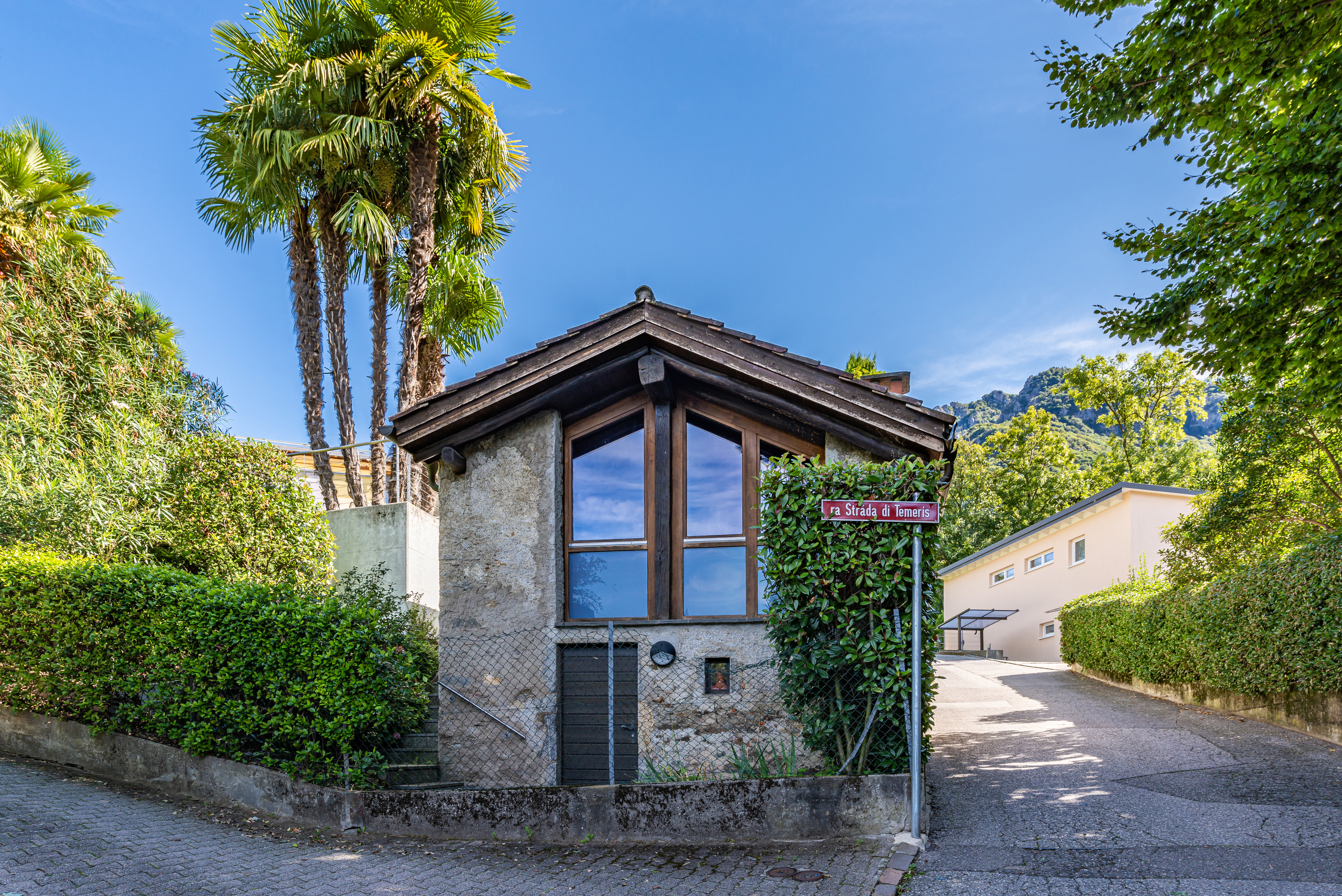 Kleines Haus mit Garten und Palmen