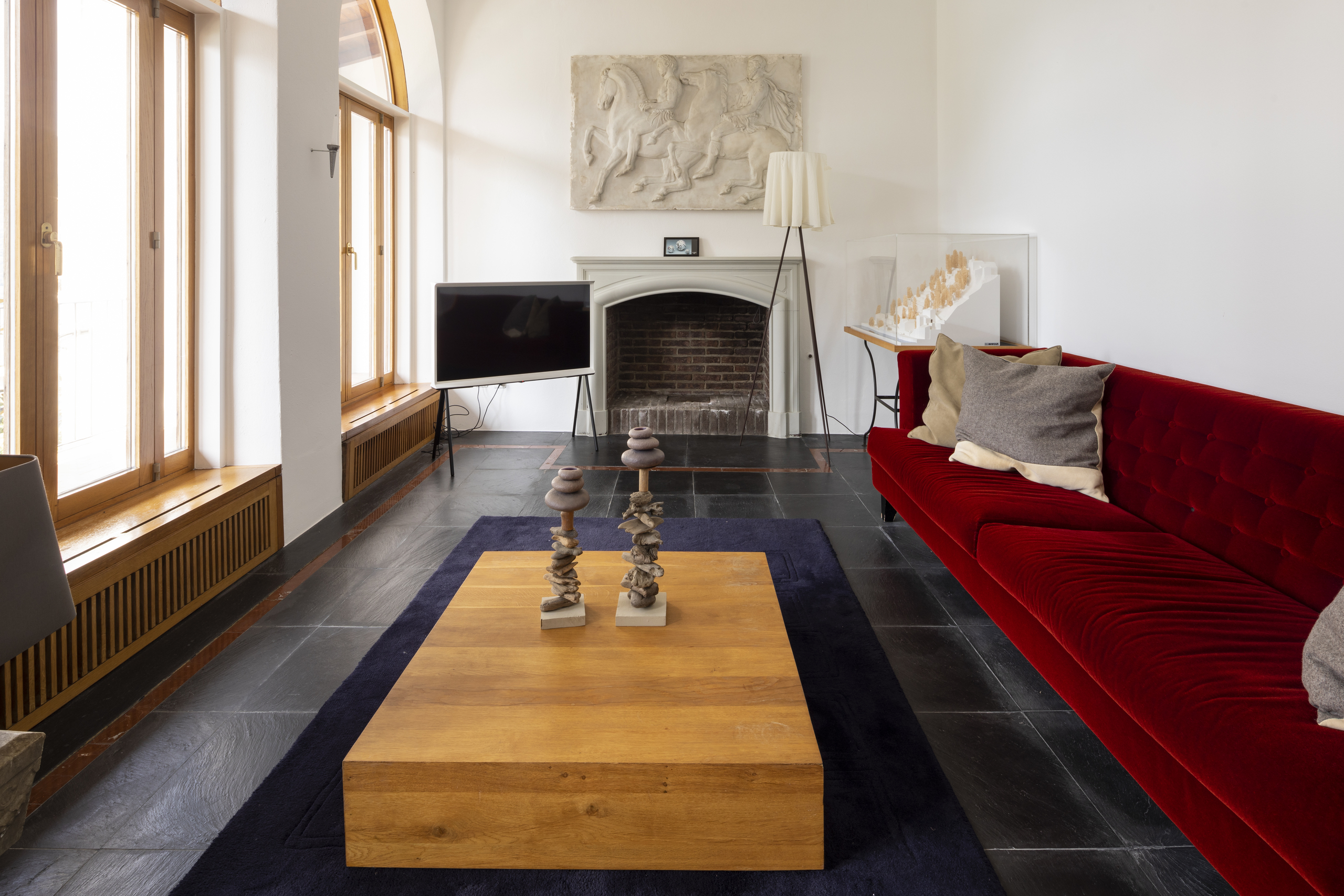 Wohnzimmer mit Kamin und rotem Sofa