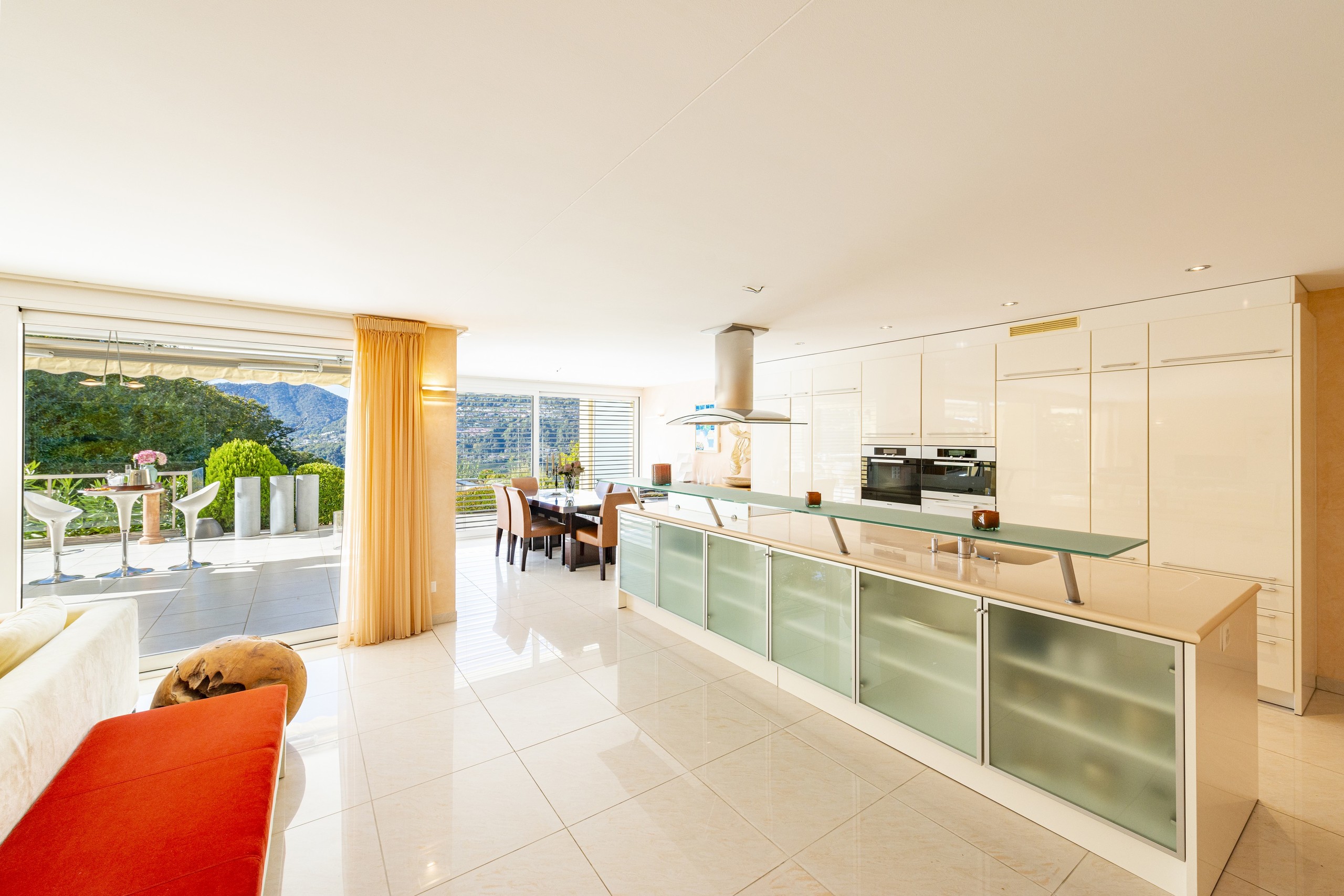Moderne offene Wohnküche mit Terrasse und Bergblick