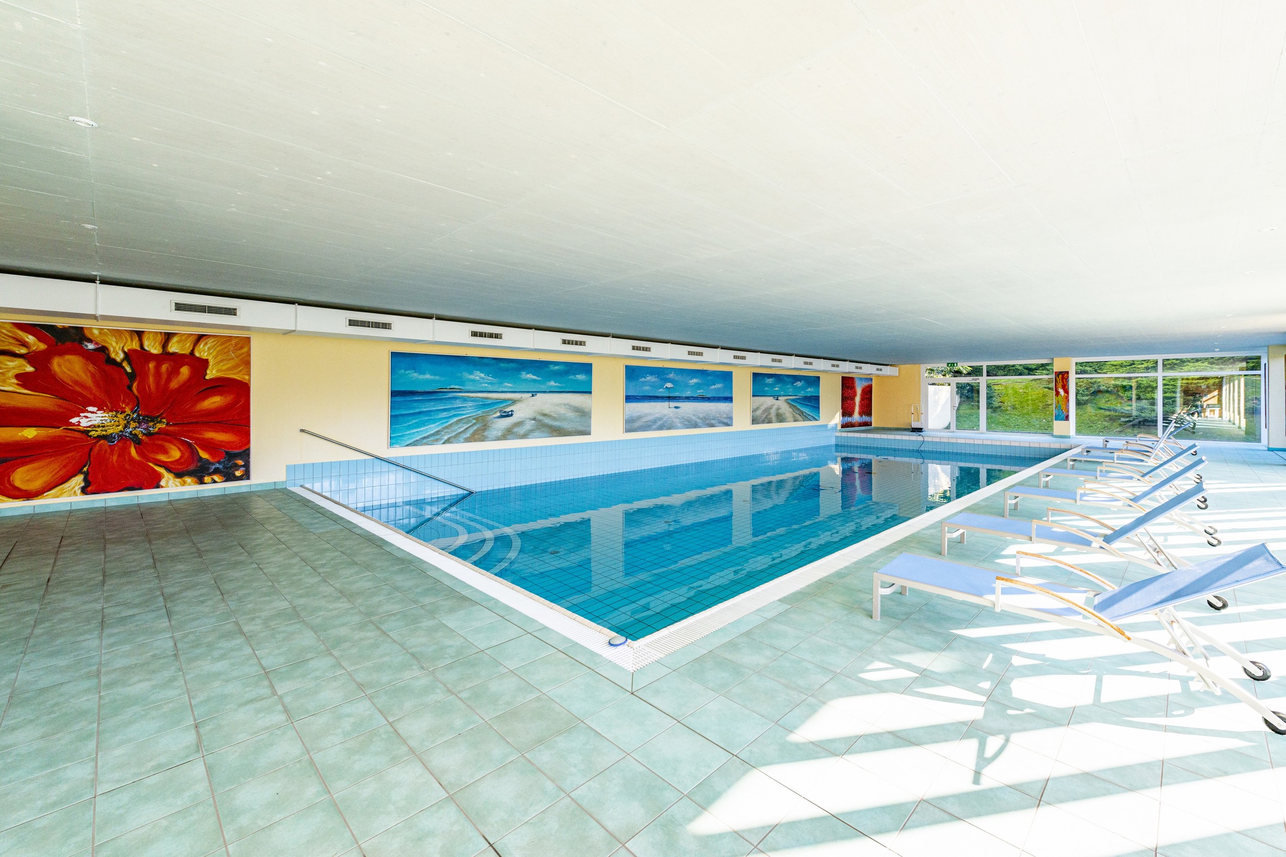 Heller Indoor-Poolbereich mit Liegen
