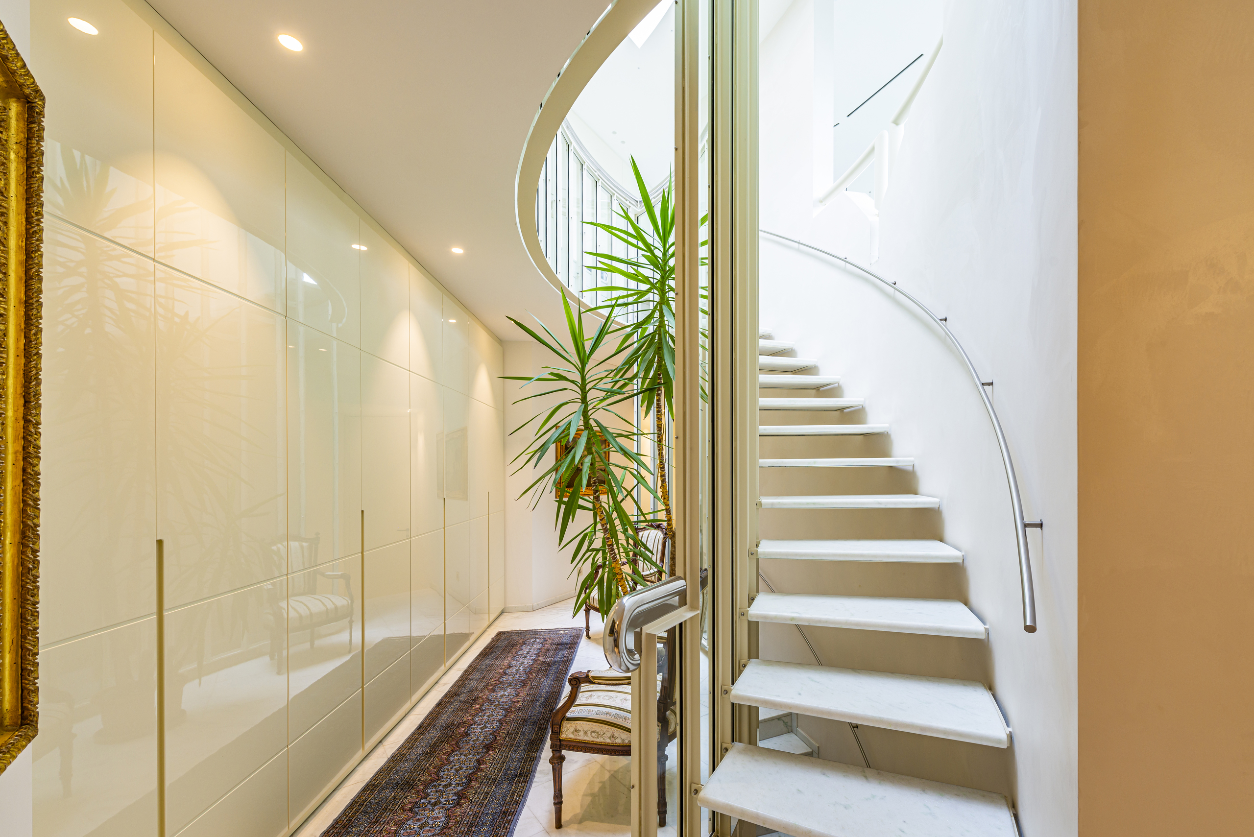 Heller Flur mit geschwungener Treppe