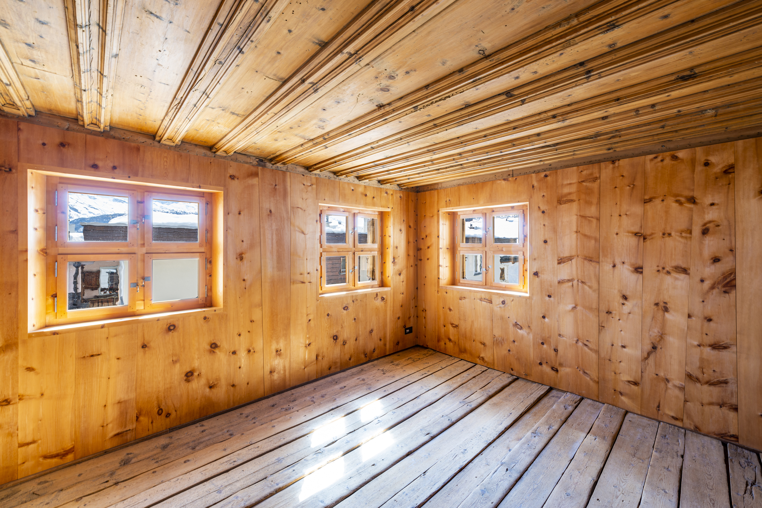 Leerer Holzraum mit Fenstern und Bergblick