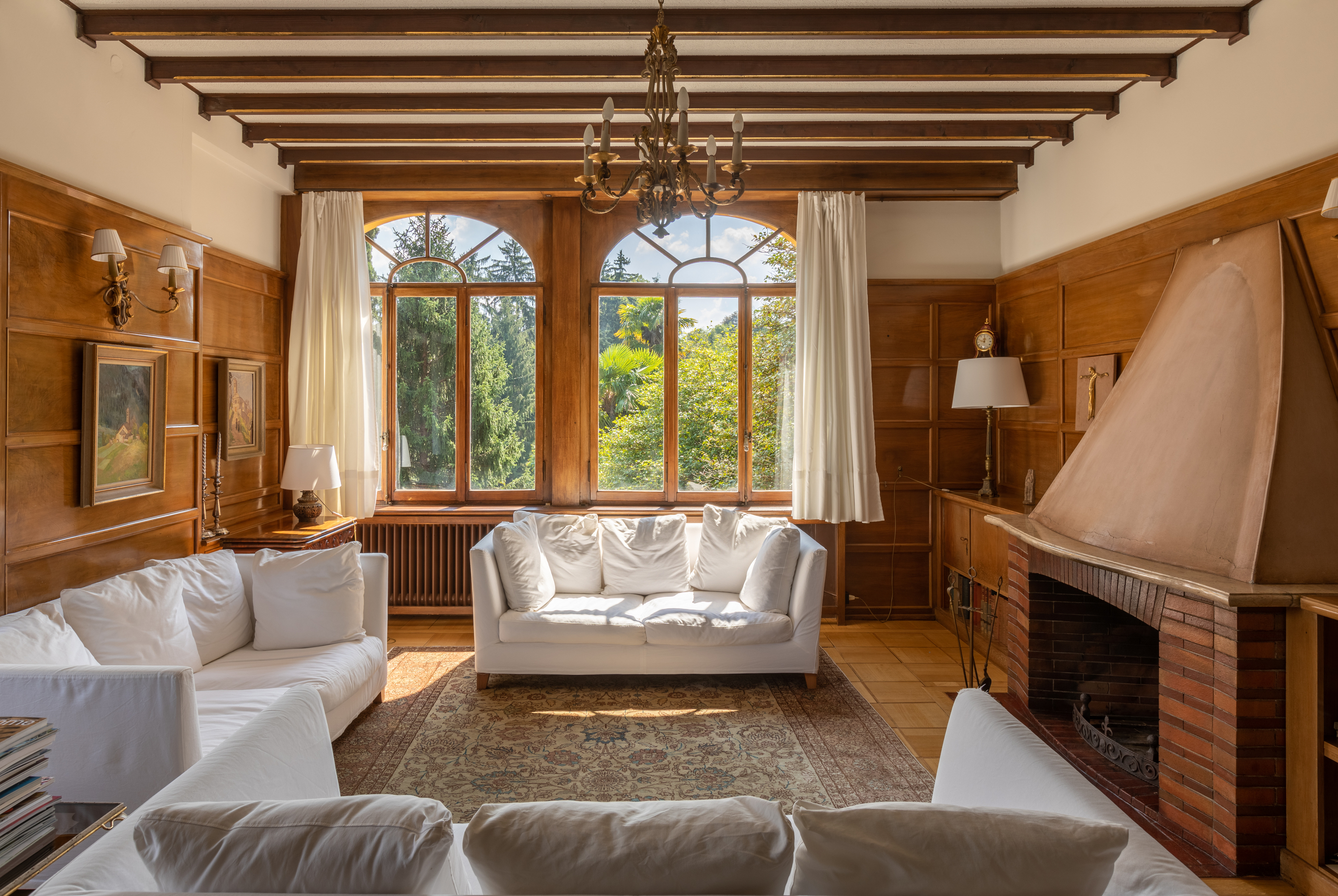 Klassisches Wohnzimmer mit Kamin und Gartenblick