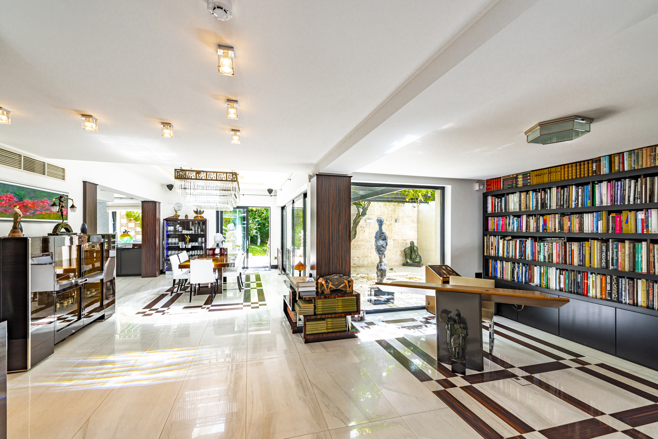 Heller Wohn- und Bibliotheksbereich mit dekorativem Boden und Gartenblick