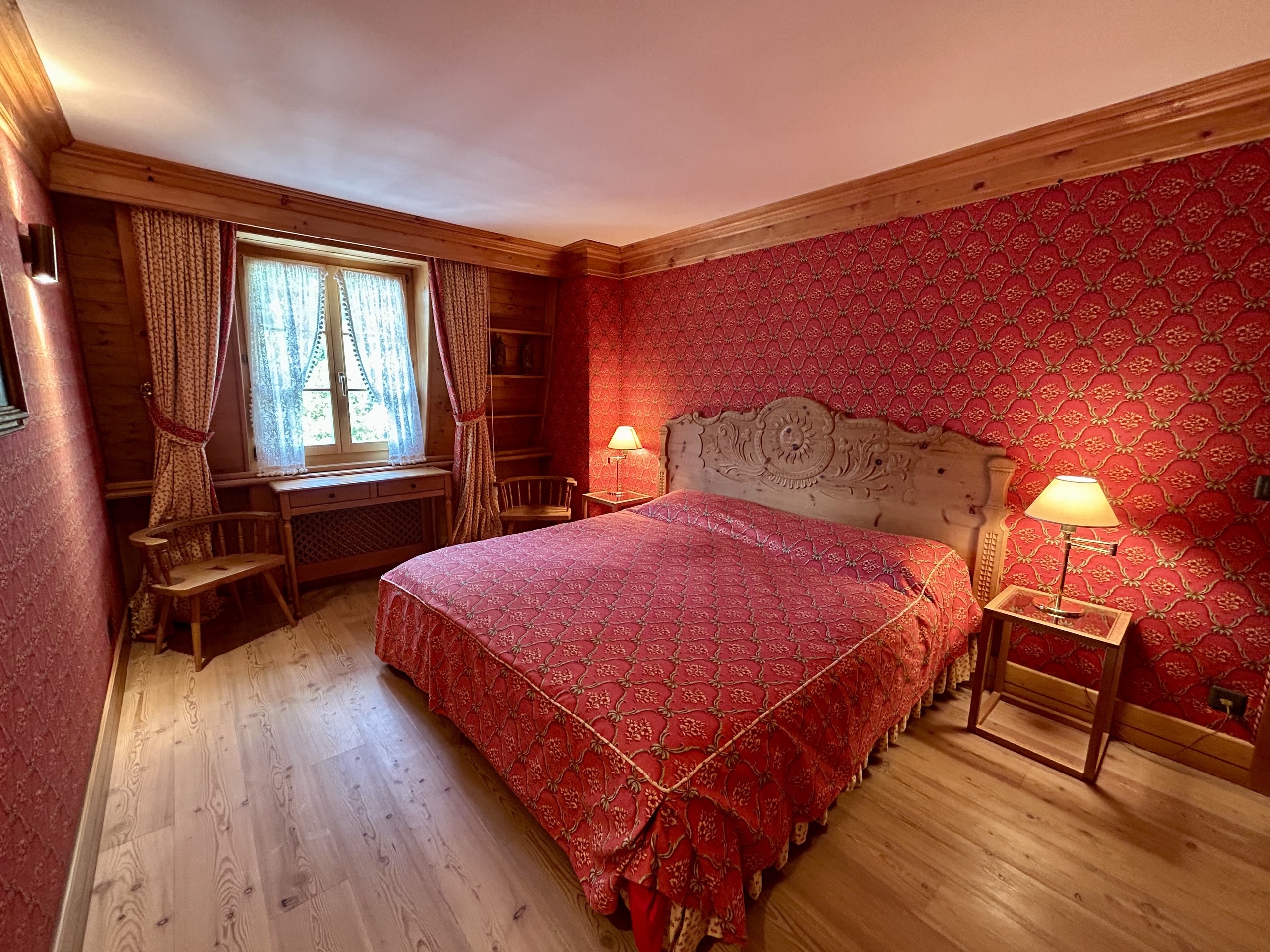 Klassisches Schlafzimmer mit roter Tapete und Holzverkleidung